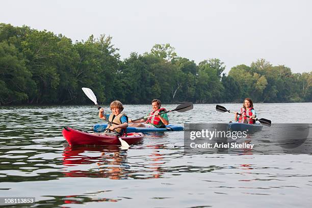 caucasian family kayaking together - canoeing stock pictures, royalty-free photos & images