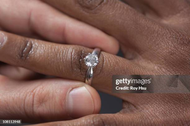 close up of man putting engagement ring on girlfriend - woman putting on diamond stock pictures, royalty-free photos & images
