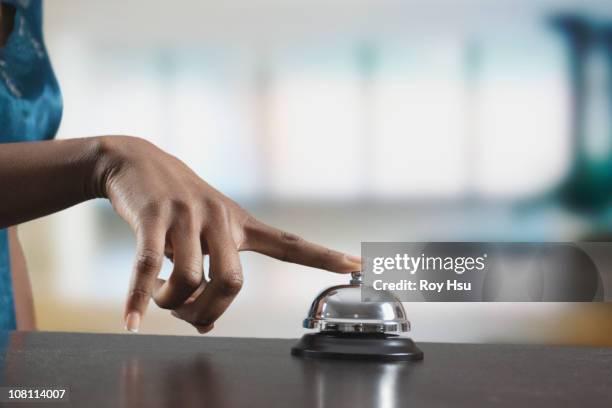 black woman ringing reception desk bell - hand with bell stockfoto's en -beelden