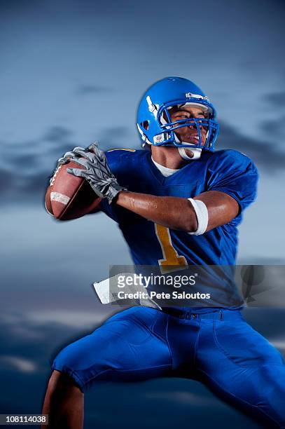 mixed race football player preparing to throw football - quarterback stockfoto's en -beelden