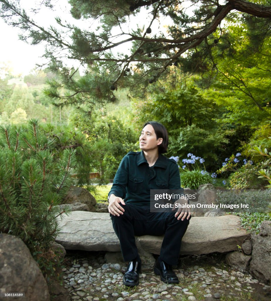 Mixed race man sitting in garden