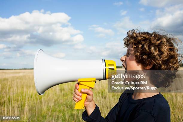 boy yelling in megaphone - megafon stock-fotos und bilder