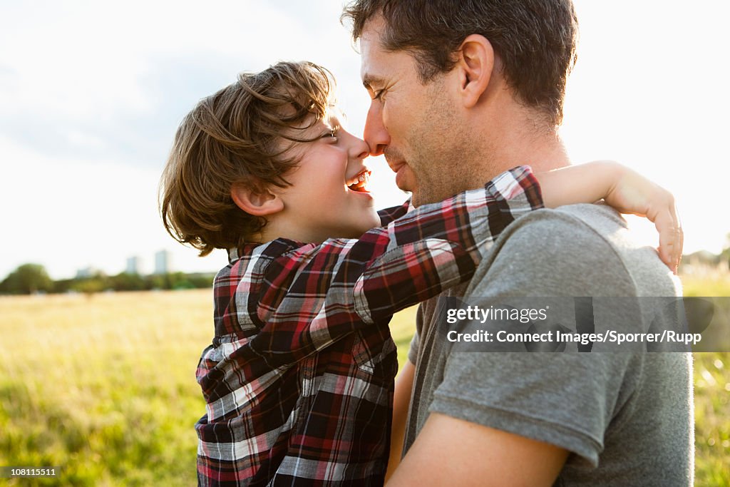 Father and son holding noses together