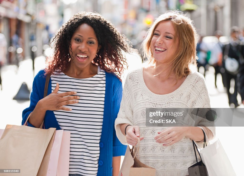 2 females walking and laughing to camera