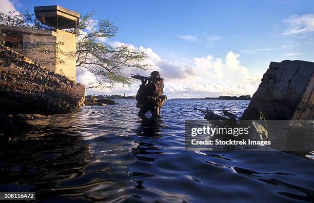 a pair of navy seal combat swimmers transition from underwater to the surface. - australian army photos et images de collection