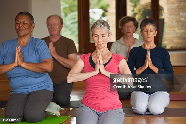 people practicing yoga together in class - woman normal old diverse stock pictures, royalty-free photos & images