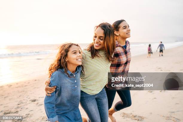 ビーチで 2 人の娘を持つ母 - teen hispanic girl ストックフォトと画像