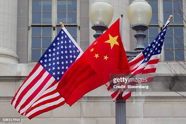 Flags of the U.S. And China fly along Pennsylvania Avenue in Washington, D.C., U.S., on Monday, Jan. 17, 2011. Hu Jintao, president of China, arrives...