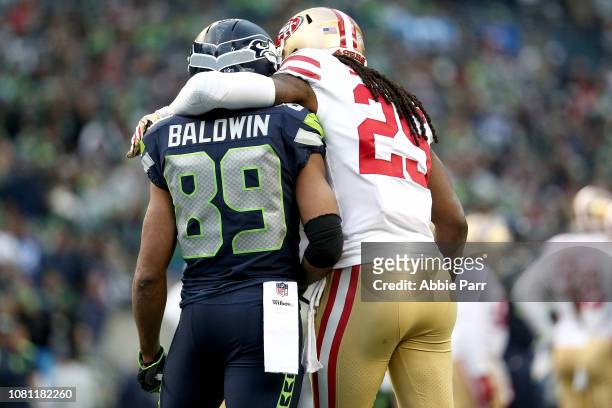 Richard Sherman of the San Francisco 49ers puts his arm around former teammate Doug Baldwin of the Seattle Seahawks in the third quarter at...