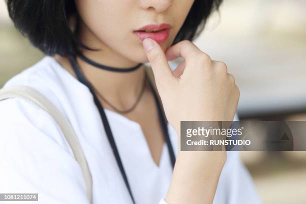 cropped image of woman touching lips - human mouth stockfoto's en -beelden