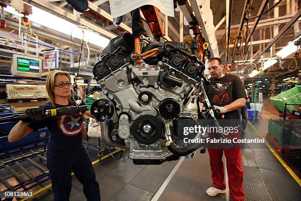 Shelley Catari and Chuck Grandbois assemble engine components for a Chrysler Minivan on the assembly line at the Chrysler Windsor Assembly plant...