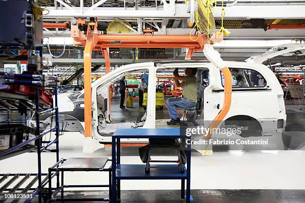 Worker helps builds a Chrysler Minivan on the assembly line at the Chrysler Windsor Assembly plant January 18, 2011 in Windsor, Ontario, Canada....