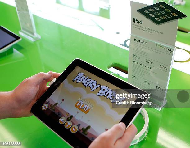 Customer looks at the Angry Birds game on an Apple Inc. IPad tablet computer at the Simply Mac store Salt Lake City, Utah, U.S., on Tuesday, Jan. 18,...