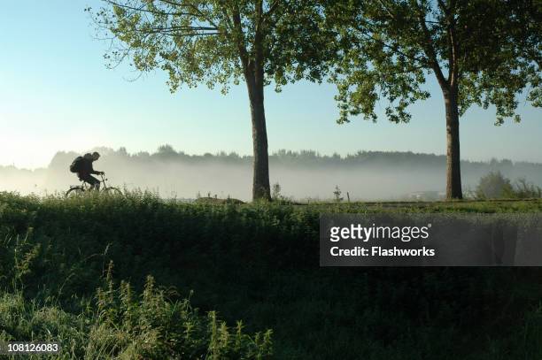persone andare in bicicletta su olandese levee durante la primavera - paesi bassi foto e immagini stock