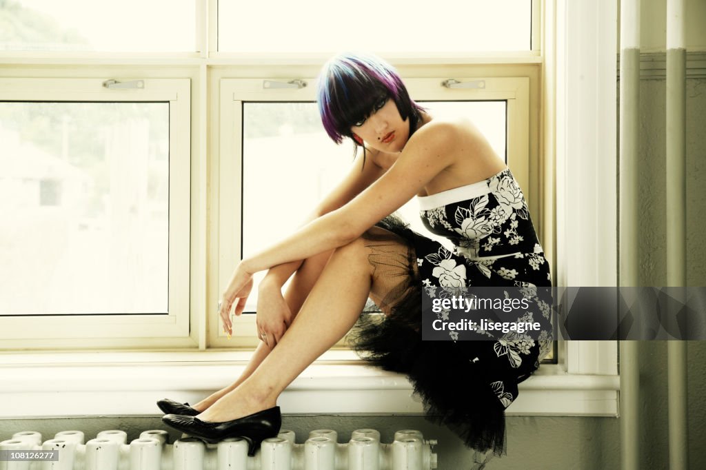 Thoughtful Woman Sitting on Windowsill