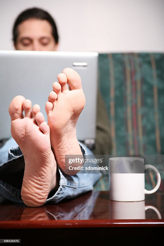 Man Relaxing With Laptop Computer