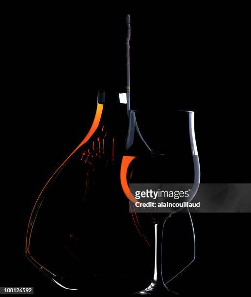 bajo luz clave retrato de botella y copa de coñac - cognac fotografías e imágenes de stock