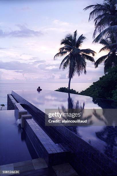 person in infinity pool at sunset on seychelles islands - infinity pool stockfoto's en -beelden