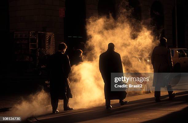 businessmen in trench coats walking to work on early morning - wall street stock pictures, royalty-free photos & images