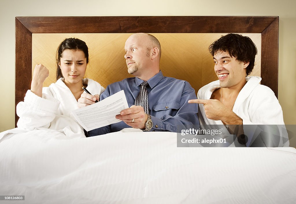Man Making Woman Sign Legal Papers in Bed