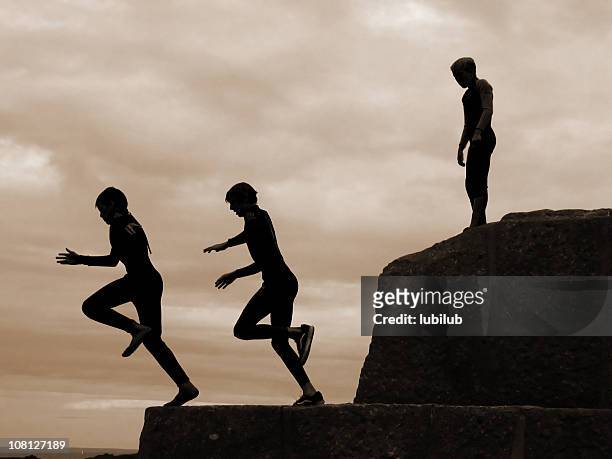 silhouette of boys cliff diving in cornwall, england - cliff diving stock pictures, royalty-free photos & images