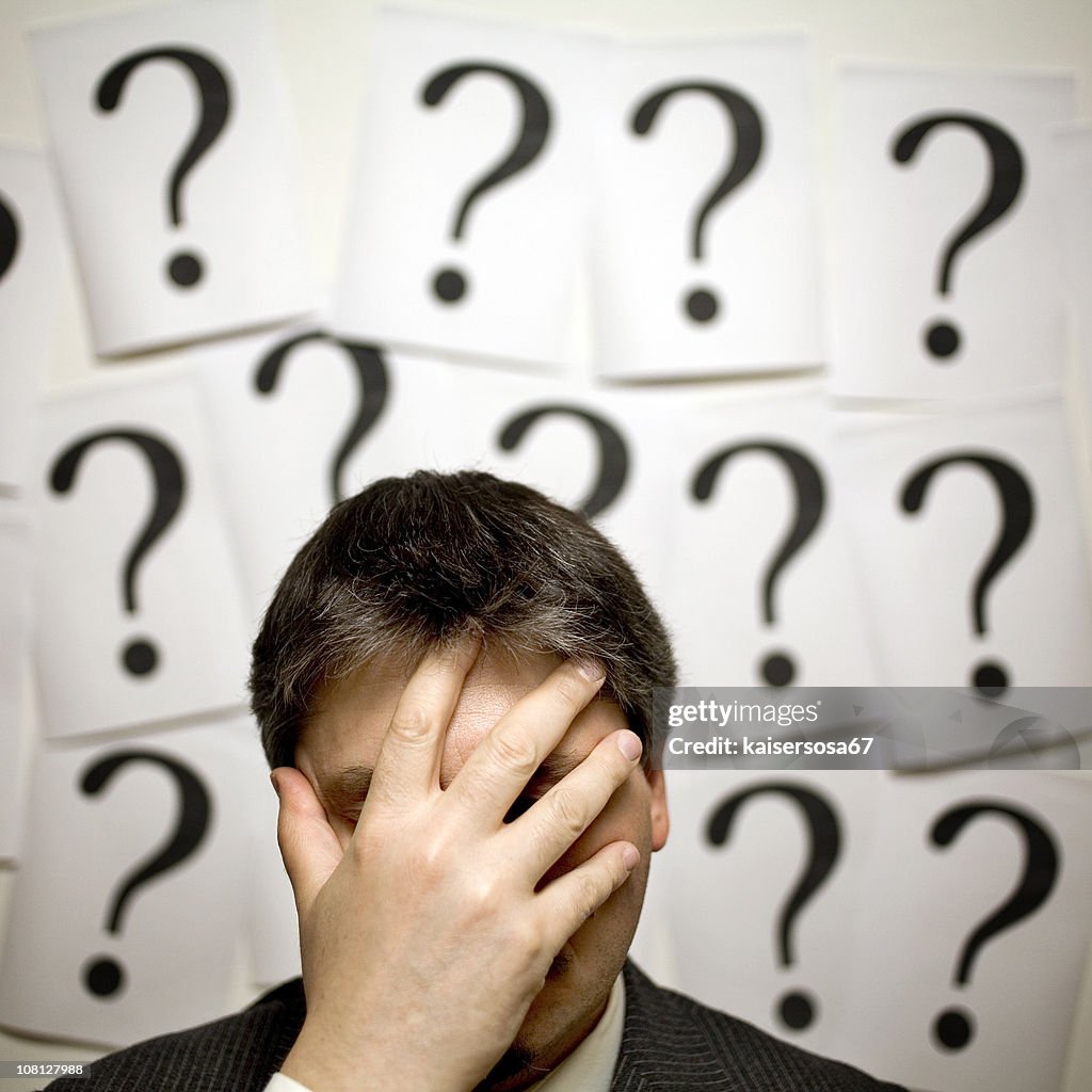 Businessman Surrounded by Question Marks