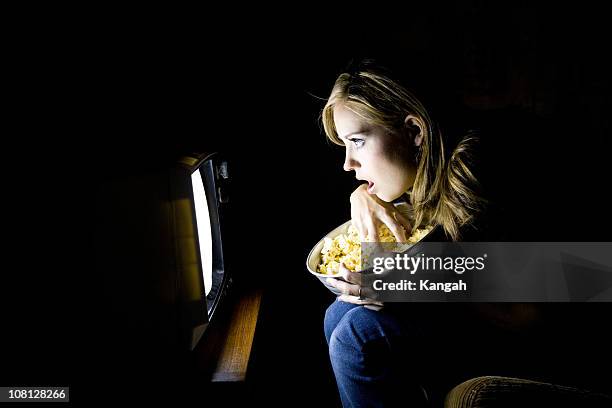 young woman watching movie in dark - bad news on tv stock pictures, royalty-free photos & images