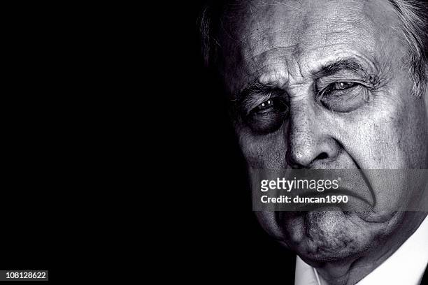 portrait of senior man frowning, black and white - dictator stock pictures, royalty-free photos & images