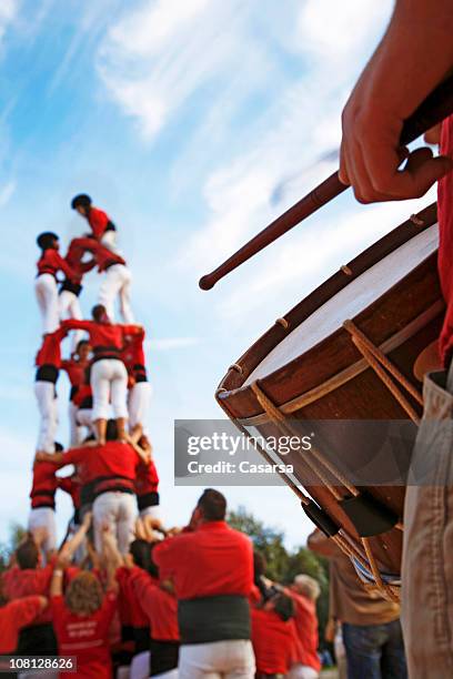 castellers and man playing drum on sunny day - mensenpiramide stockfoto's en -beelden