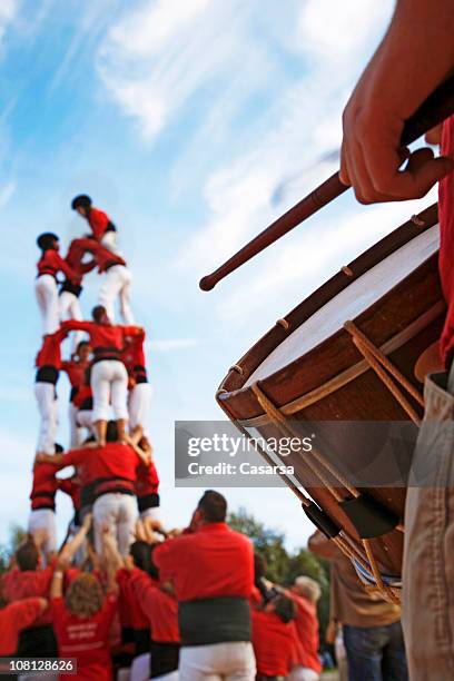 castellers and man playing drum on sunny day - castell stock pictures, royalty-free photos & images
