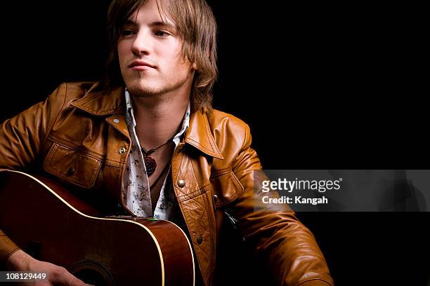 young male holding guitar - country and western music stock pictures, royalty-free photos & images