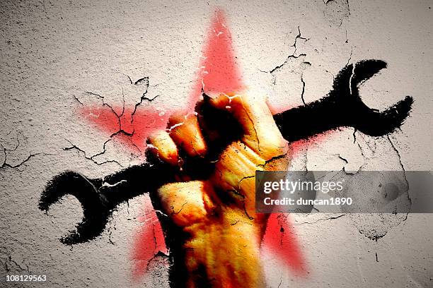 graffiti de man main tenant la clé à écrous avec étoile rouge derrière - socialisme photos et images de collection