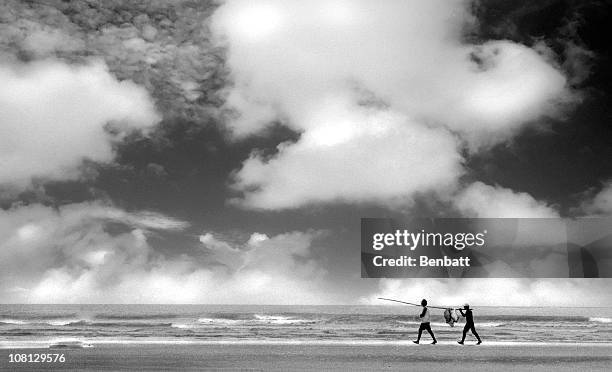 fishermen carrying catch along beach, black and white - jericoacoara stockfoto's en -beelden