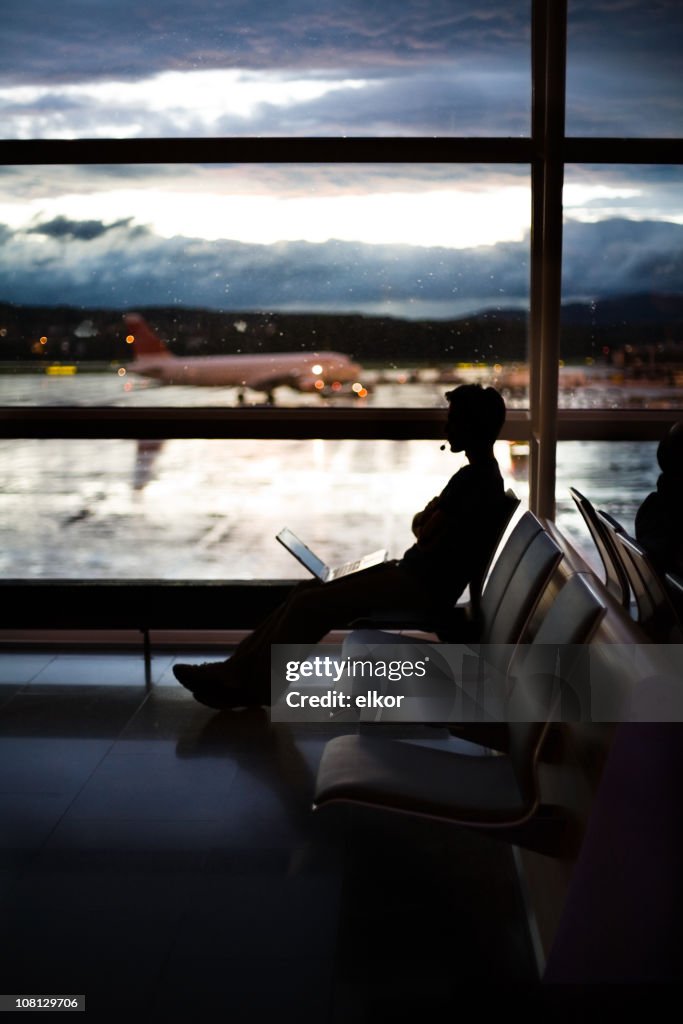 Silhouette of Businessman Sitting in Airport Terminal