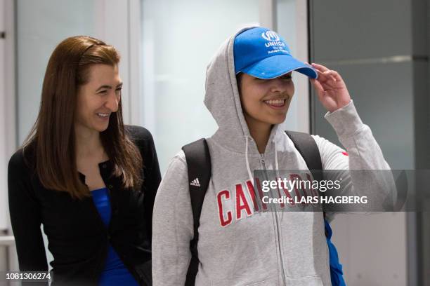 Saudi teenager Rahaf Mohammed al-Qunun arrives at Pearson International airport in Toronto, Ontario, on January 12, 2019. The woman on the left is...