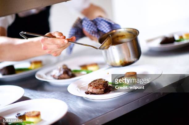 steak on a plate being prepared in a chef's kitchen sauce pouring - au loin stock pictures, royalty-free photos & images