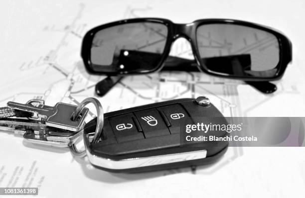 electronic car keys and sunglasses on a table - car keys table stock-fotos und bilder