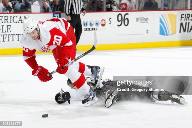 Drew Miller of the Detroit Red Wings gets tripped up by a Pittsburgh Penguins defender on January 18, 2011 at Consol Energy Center in Pittsburgh,...