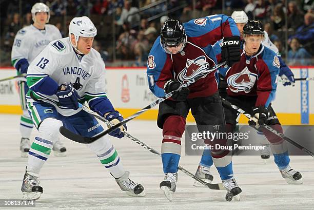 Philippe Dupuis of the Colorado Avalanche controls the puck with his skate while under pressure from Raffi Torres of the Vancouver Canucks at the...