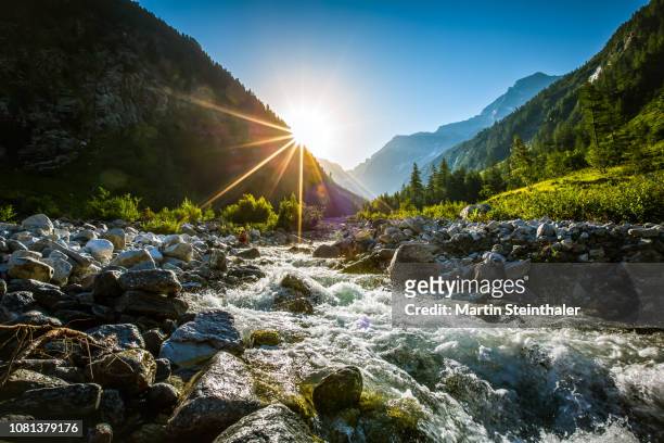 frei fließendes flussbett bei sonnenaufgang - mountain range sunrise stock pictures, royalty-free photos & images