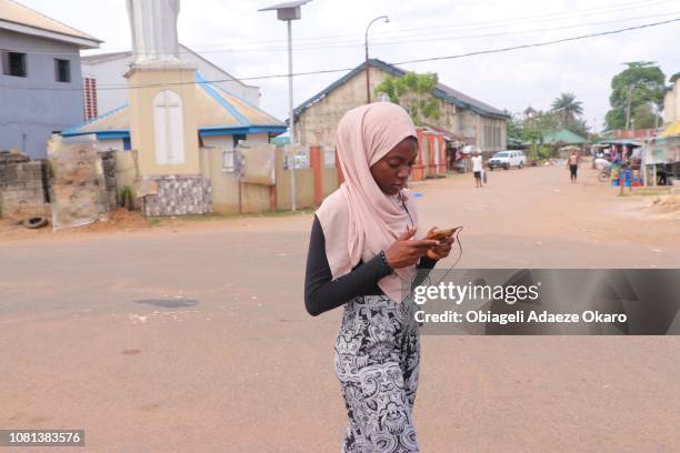 a girl walking on the streets of her community - ナイジェリア ストックフォトと画像