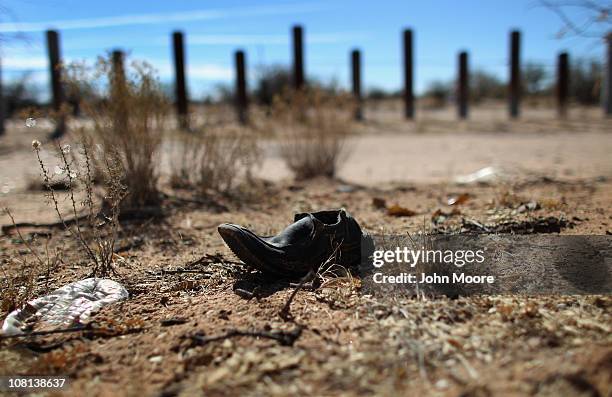 Discarded shoe lies along the porous U.S.-Mexico border fence which stretches through the Sonoran Desert on January 18, 2011 in the Tohono O'odham...