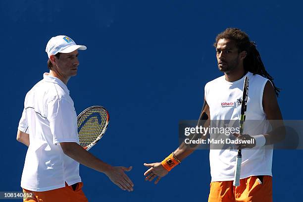 Dustin Brown of Germany shakes hands with his teammate Rogier Wassen of The Netherlands following their first round doubles match against Dmitry...
