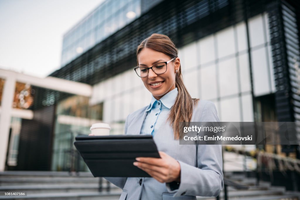 Portrait of a business woman using digital tablet outdoors