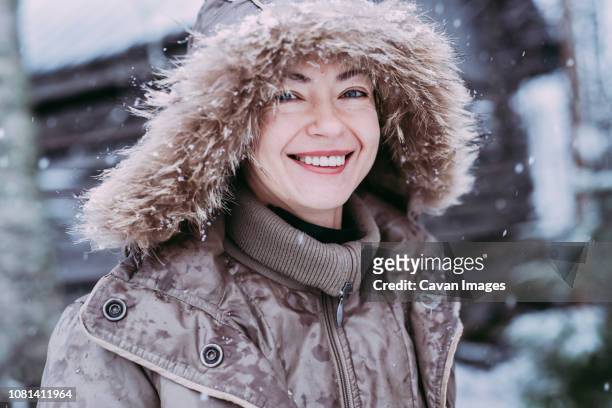 close-up portrait of happy woman standing outdoors during snowfall - finland women stock pictures, royalty-free photos & images