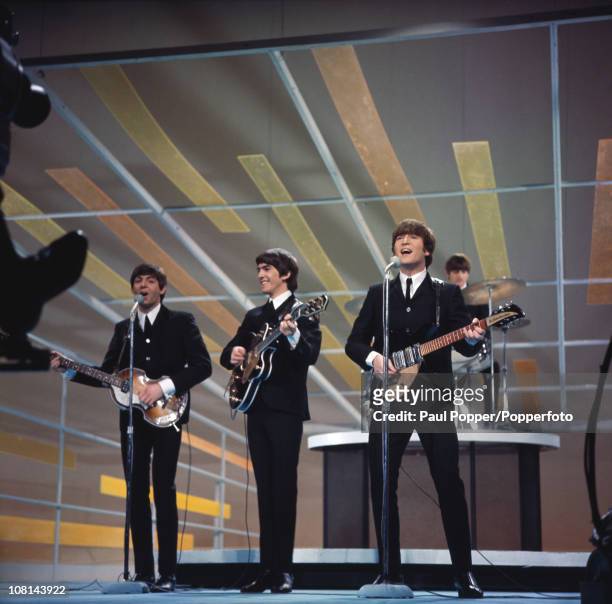 View of the members of British Rock group the Beatles as they perform onstage during their debut appearance on 'The Ed Sullivan Show' at CBS's Studio...