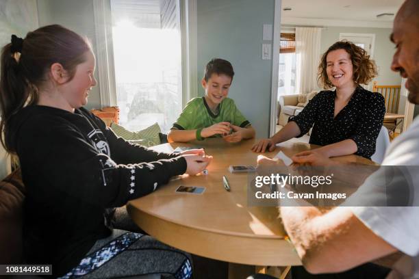 happy family playing poker on table at home - poker table stock pictures, royalty-free photos & images