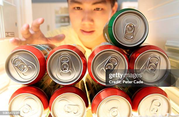 chinese man picking can out of fridge - beer fridge stock-fotos und bilder