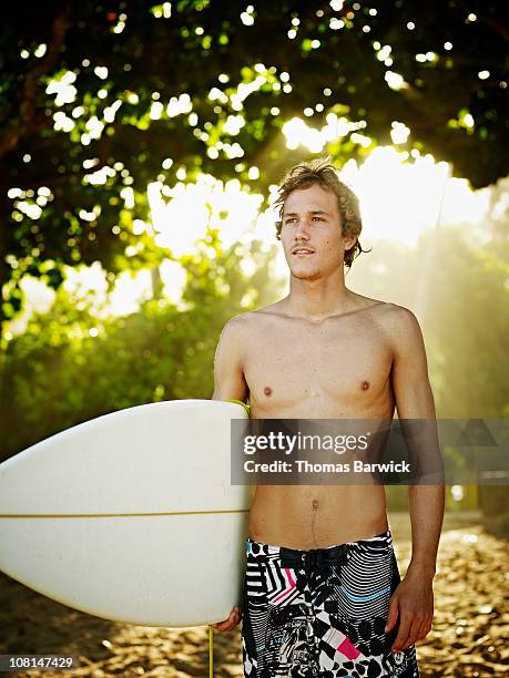 surfer standing with surfboard looking out - surfbrett stock-fotos und bilder
