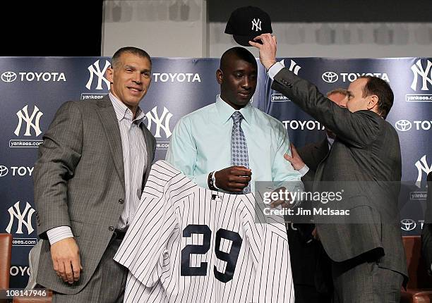 Rafael Sorianoof the New York Yankees is presented his jersey and cap from manager Joe Girardi and general manager Brian Cashman during his...